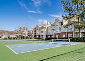 Thumbnail 4 of 18 - A tennis court is surrounded by apartment buildings. at Greenbrier Estates, Slidell, 70460
