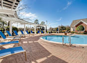 Thumbnail 3 of 18 - A pool surrounded by sun loungers and a white pergola. at Greenbrier Estates, Slidell, 70460