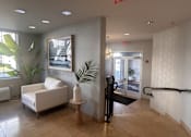 Thumbnail 37 of 46 - a view of the lobby of an office building with a white chair and a plant at Pier Village Apartments, Long Branch, 07740
