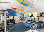 Thumbnail 10 of 31 - a gym with cardio equipment and a surfboard on the ceiling at Quail Ridge, Plainsboro Township