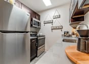 Thumbnail 16 of 31 - a kitchen with stainless steel appliances and black cabinets at Quail Ridge, Plainsboro Township, 08536
