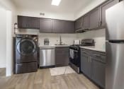 Thumbnail 34 of 51 - a kitchen with gray cabinets and stainless steel appliances at Copper and Quarry Village, Maryland, 21209