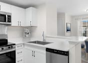 Thumbnail 5 of 35 - A modern kitchen with white cabinets and appliances. at Reflection Pointe, Flowood, Mississippi