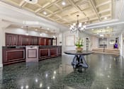 Thumbnail 5 of 26 - A spacious kitchen with dark wood cabinets and a marble countertop.