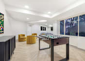 Thumbnail 8 of 26 - A room with a foosball table and a framed picture on the wall.