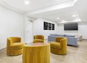 Thumbnail 6 of 26 - A room with yellow chairs and a grey couch.