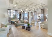 Thumbnail 4 of 26 - A spacious living room with a large window and a view of trees and buildings outside.
