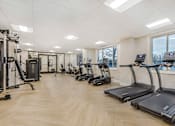 Thumbnail 3 of 26 - A gym with treadmills, weights, and exercise equipment.