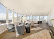 Thumbnail 1 of 26 - A spacious room with grey chairs and a view of the city.