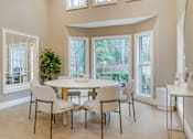 Thumbnail 4 of 21 - A dining room with a table and chairs.
