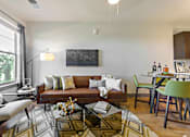 Thumbnail 8 of 13 - a living room and dining room with a couch and chairs and a table with a chair  at The Addison, Baton Rouge, LA