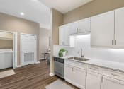 Thumbnail 17 of 20 - a white kitchen with white cabinets and a stainless steel sink