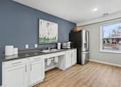 Thumbnail 9 of 31 - A kitchen with white cabinets and a black fridge.