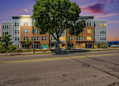 Thumbnail 10 of 40 - a city street with an apartment building at sunset
