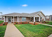 Thumbnail 4 of 43 - A house with a brown roof and a grey front porch.