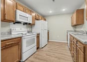 Thumbnail 2 of 31 - A kitchen with white appliances and wooden cabinets.