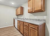Thumbnail 1 of 31 - A kitchen with wooden cabinets and a marble countertop.