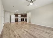 Thumbnail 16 of 22 - A room with a ceiling fan and wooden flooring.