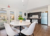 Thumbnail 7 of 36 - a dining area with a table and chairs and a kitchen in the background