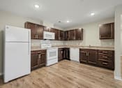 Thumbnail 15 of 22 - A kitchen with white appliances and wooden cabinets.