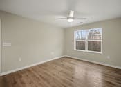 Thumbnail 9 of 43 - Empty room with wood flooring and a ceiling fan.