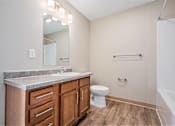 Thumbnail 16 of 30 - A bathroom with a white toilet and a marble counter top.