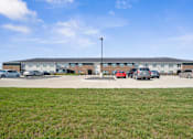 Thumbnail 21 of 38 - a parking lot with cars in front of a building