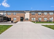 Thumbnail 12 of 38 - a large brick building with a concrete walkway in front of it