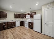 Thumbnail 10 of 43 - A kitchen with brown cabinets and white appliances.