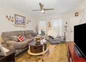 Thumbnail 15 of 36 - a living room with white walls and a ceiling fan