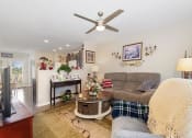 Thumbnail 16 of 36 - a living room filled with furniture and a ceiling fan