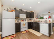 Thumbnail 22 of 36 - a kitchen with dark cabinets and white appliances