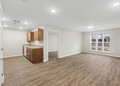 Thumbnail 14 of 31 - A spacious room with wooden flooring and a cabinet with a countertop.