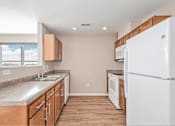 Thumbnail 14 of 30 - A kitchen with a white refrigerator, wooden cabinets, and a marble countertop.