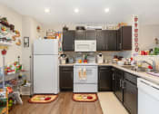 Thumbnail 26 of 36 - a kitchen with white appliances and black cabinets