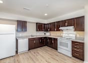 Thumbnail 19 of 42 - A kitchen with brown cabinets and a white refrigerator.