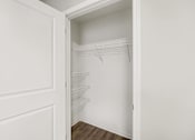 Thumbnail 20 of 31 - A white closet with a door open and a shelf.