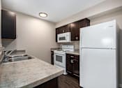 Thumbnail 19 of 40 - a kitchen with white appliances and dark wood cabinets