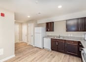 Thumbnail 24 of 42 - A kitchen with white appliances and brown cabinets.