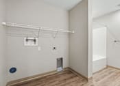 Thumbnail 19 of 31 - A room with a white wall, a white door, a white shelf, and a white chair.