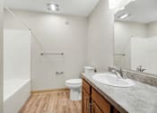 Thumbnail 13 of 31 - A white toilet sits in a bathroom with a sink and a bathtub.