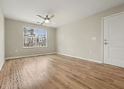 Thumbnail 13 of 22 - A room with a ceiling fan and a picture of a house on the wall.