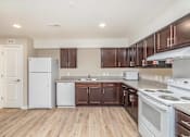 Thumbnail 21 of 42 - A kitchen with white appliances and wooden cabinets.