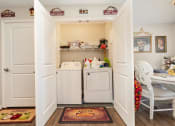 Thumbnail 28 of 36 - a laundry room with a washer and dryer and a table and chairs