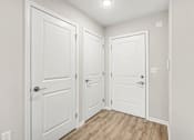 Thumbnail 30 of 31 - Three white doors in a hallway with wood flooring.