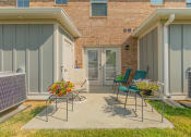 Thumbnail 21 of 36 - a patio with two chairs and two tables in front of a brick building