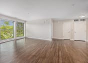 Thumbnail 28 of 34 - an empty living room with wood floors and a large window