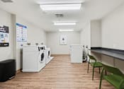 Thumbnail 27 of 31 - A laundromat with washers and dryers and a sign that says "Easy".