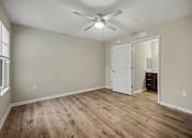 Thumbnail 26 of 43 - A room with a ceiling fan and wooden flooring.
