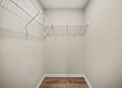 Thumbnail 27 of 43 - A white wire shelf is mounted on a white wall above a wooden floor.